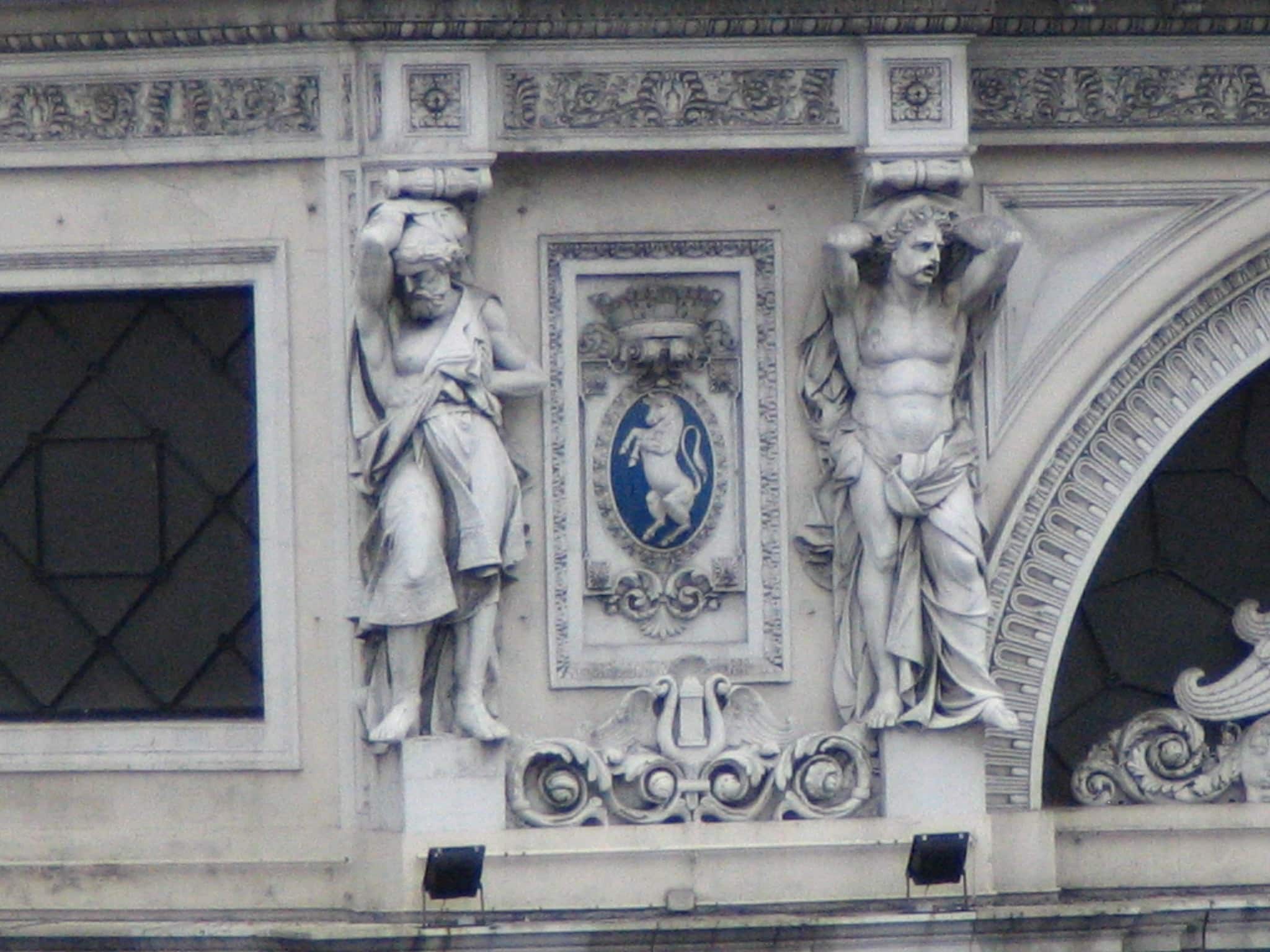 Statues on a Genoa building holding up the roof