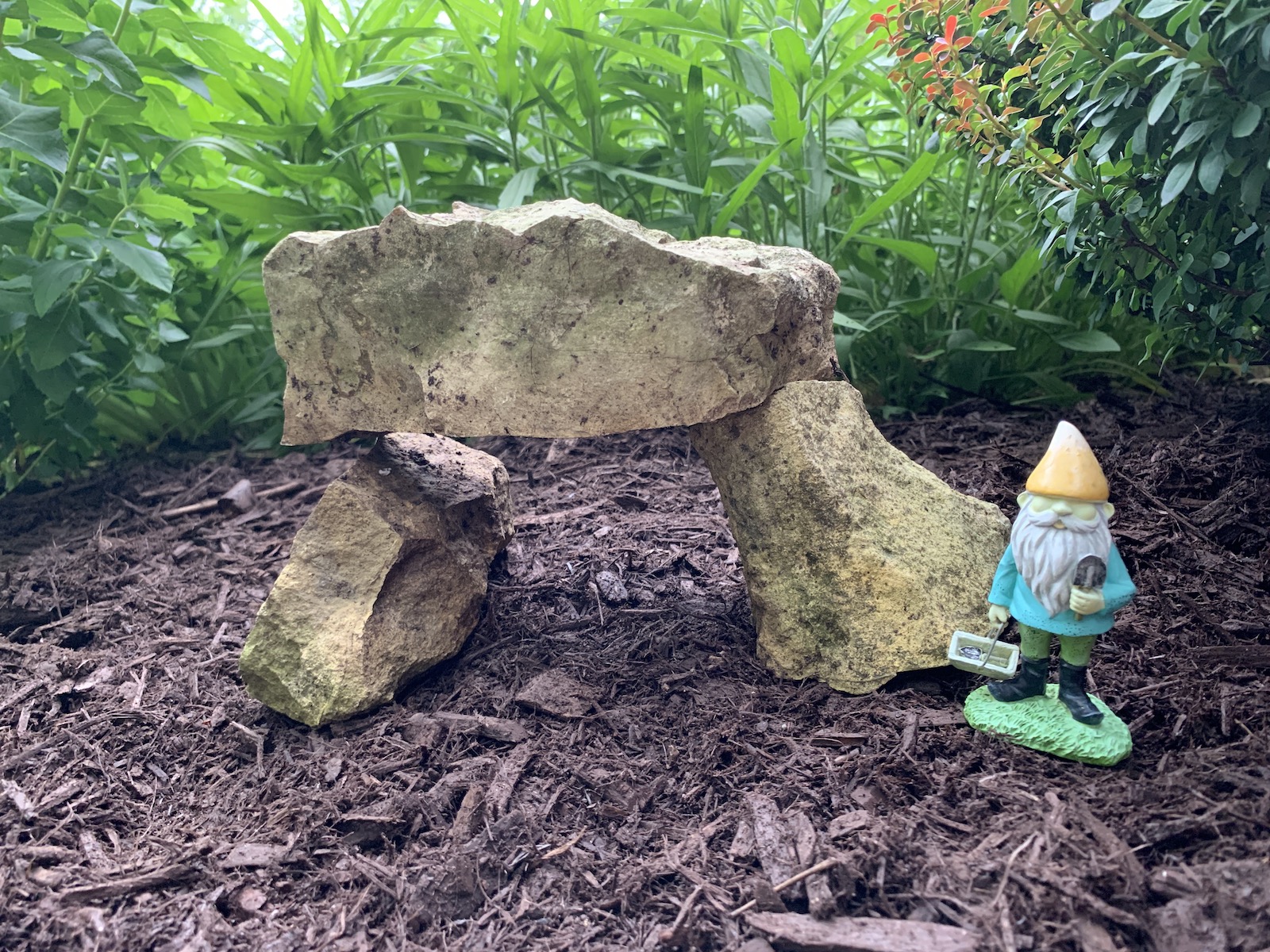 Rocks arranged like Stonehenge with a garden gnome